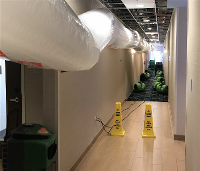 water damage equipment set up in a hallway of a flooded hotel. 